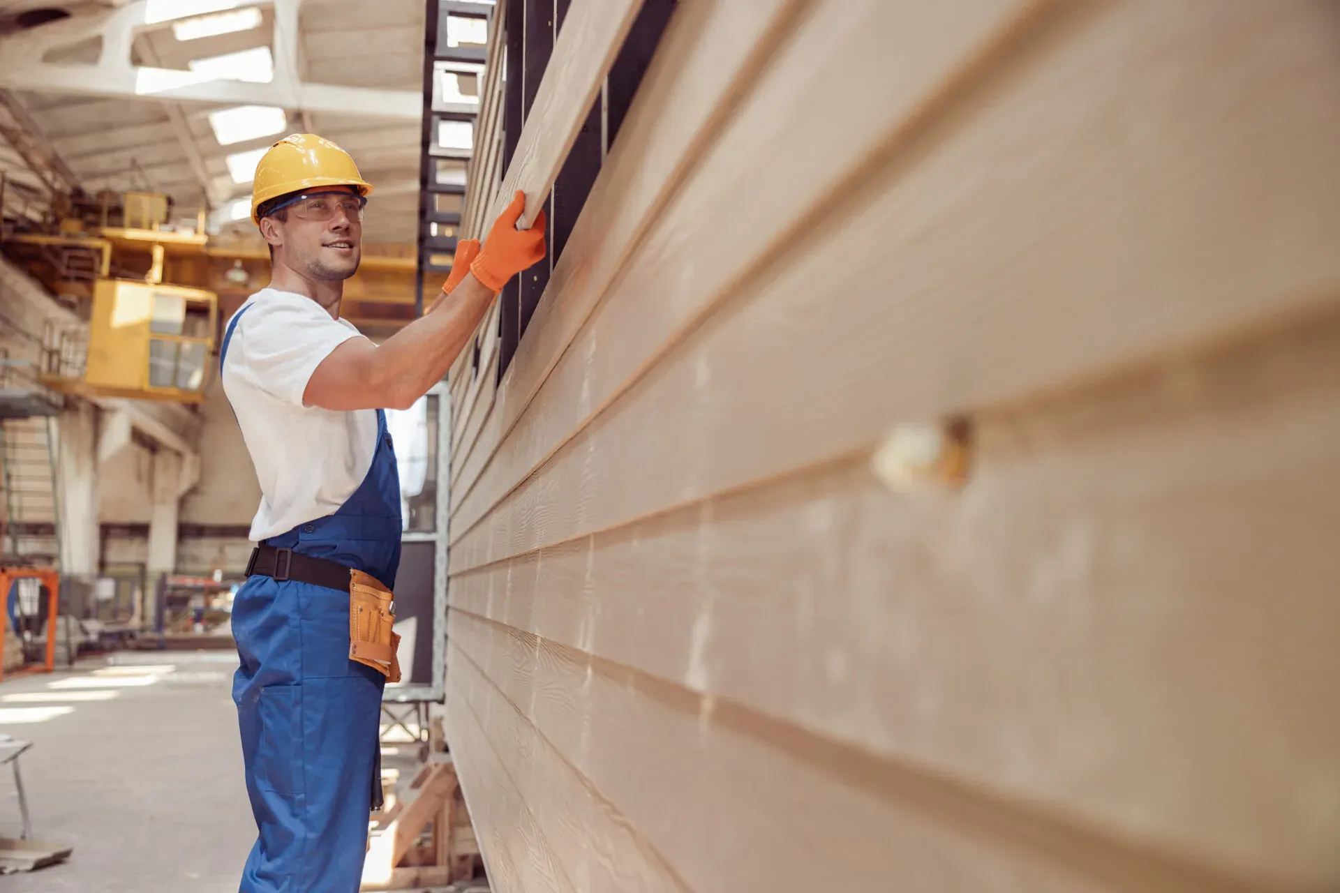 Man installing vinyl siding on a mmanufactured home